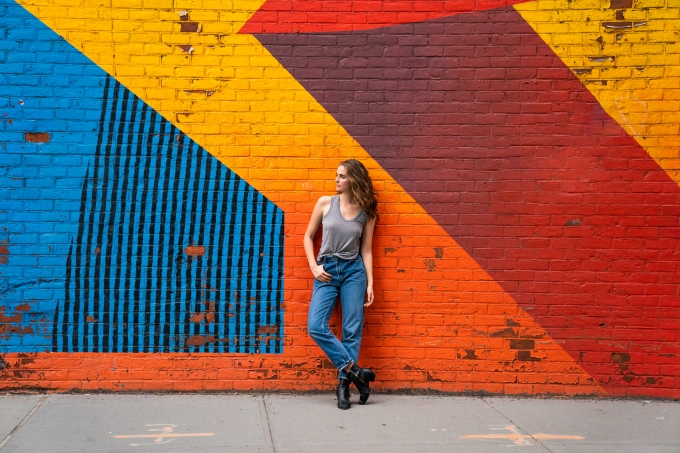 Image of woman against colored wall by Chris Orwig.